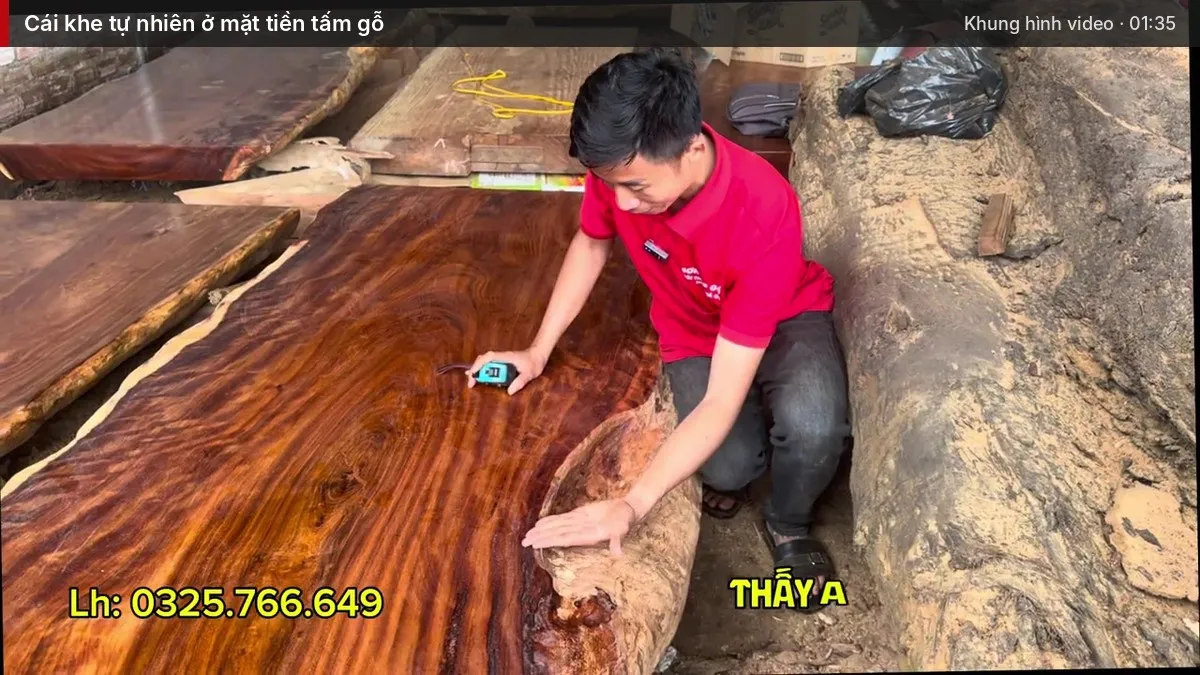 Em Chiến chạm tay vào khe gỗ tự nhiên ở mặt tiền tấm gỗ