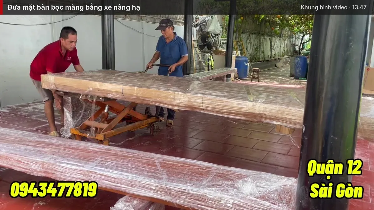 Cả nhóm đưa mặt bàn bọc màng bằng xe nâng hạ