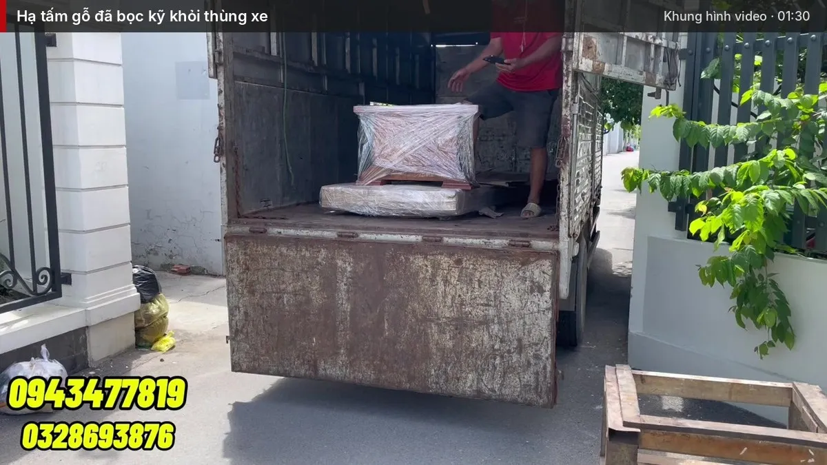 Hạ tấm gỗ đã bọc kỹ khỏi thùng xe Hạ tấm gỗ đã bọc kỹ khỏi thùng xe